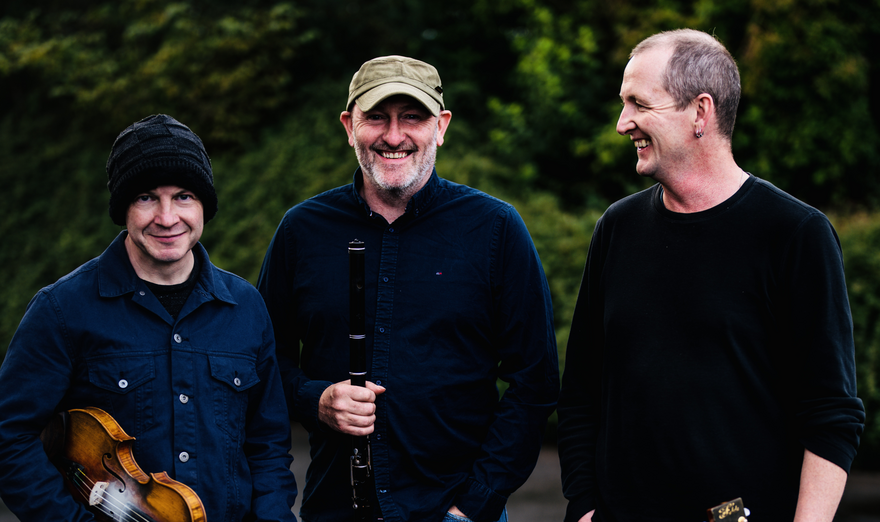 Michael McGoldrick, John McCusker and John Doyle holding their instruments 