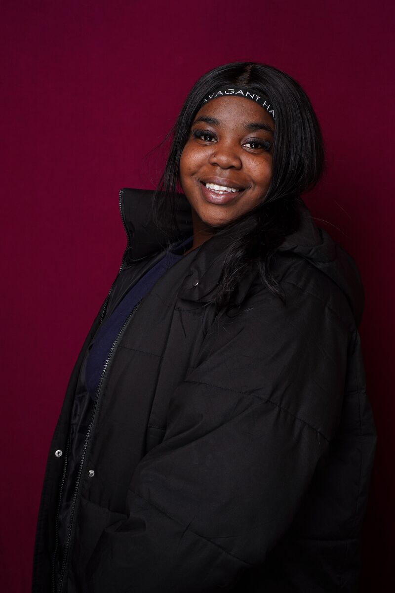 Yanai wearing a headband and black jacket smiling into the camera