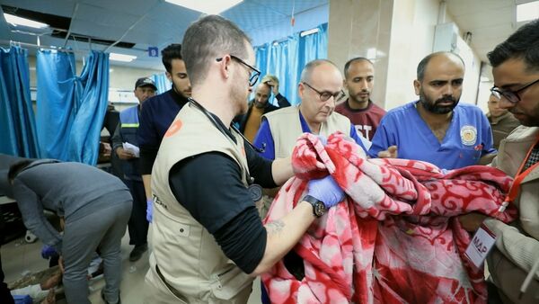 A group of medics work closely together in a hospital ward. A group of medics work closely together in a hospital ward.