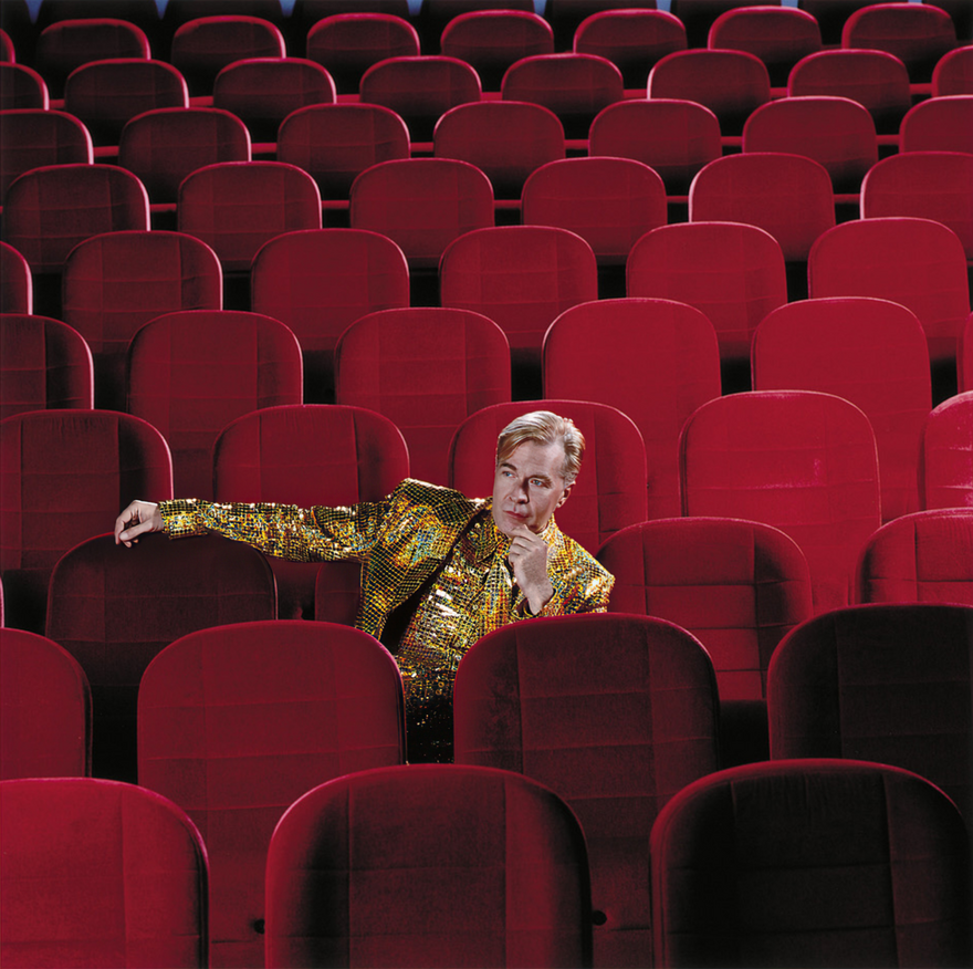 Martin Fry sat in a sparkly golden suit on red theatre chairs