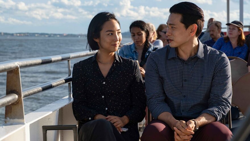 A young couple sit together on a boat.