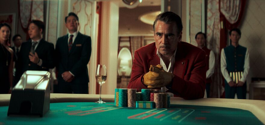 A man sits at a casino table with a large pile of chips. 