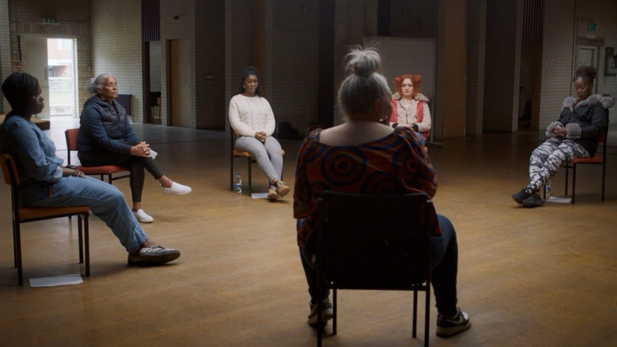 6 people sat on chairs in a circle