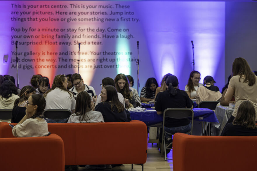 Students sit around a table, doings an activity 