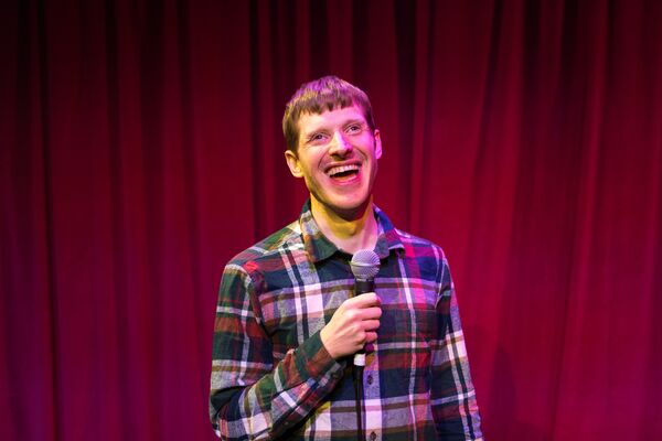 David Eagle in a plaid shirt holding a microphone 