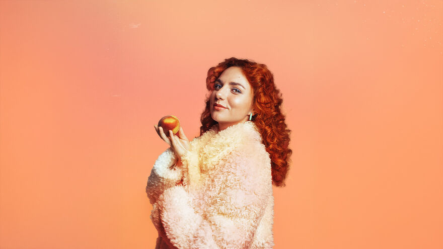 Ania Magliano in a fluffy coat holding a peach