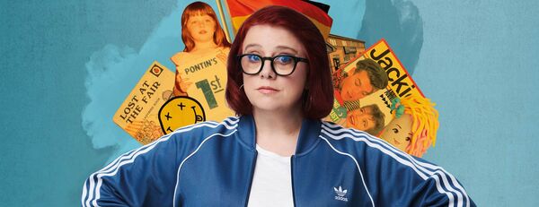 Angela Barnes in a blue track jacket with old books and photos behind her
