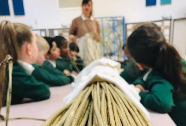 Students sitting at a table with lots of willow on it.