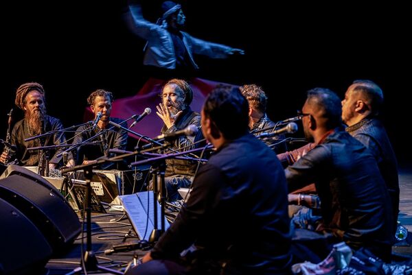 Band sat on the floor in a semi-circle