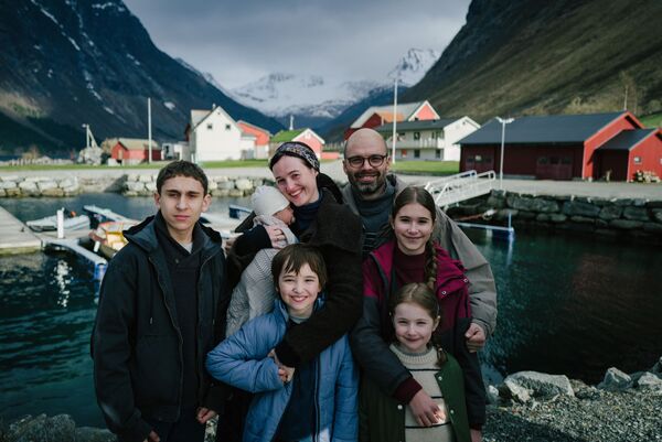 A family pose for a photo in a fjord. 