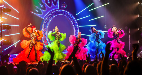5 Drag queens in colourful outfits on stage