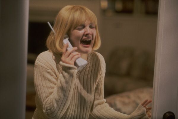 A young woman screams into a phone. 