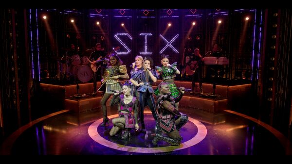 Six women perform on stage as the wives of Henry VIII. 