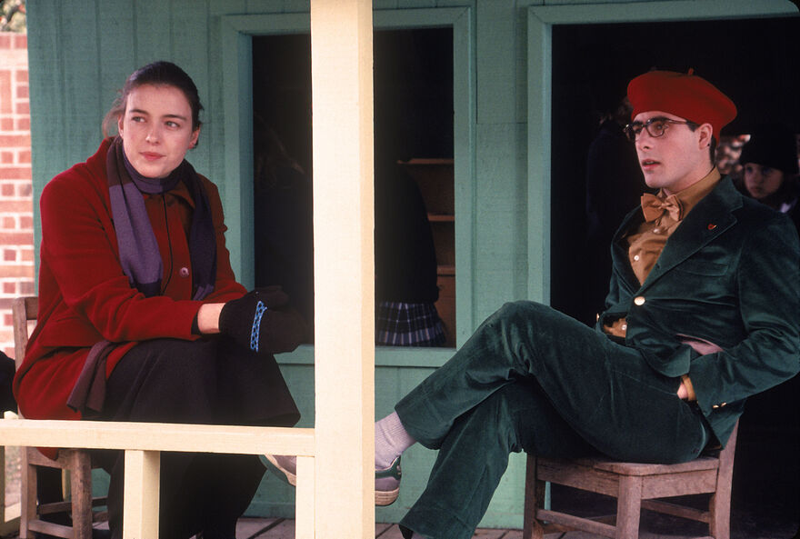 A young man and woman sit together on a porch.