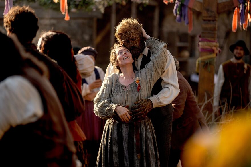 A woman and a man made of wicker dance together. 