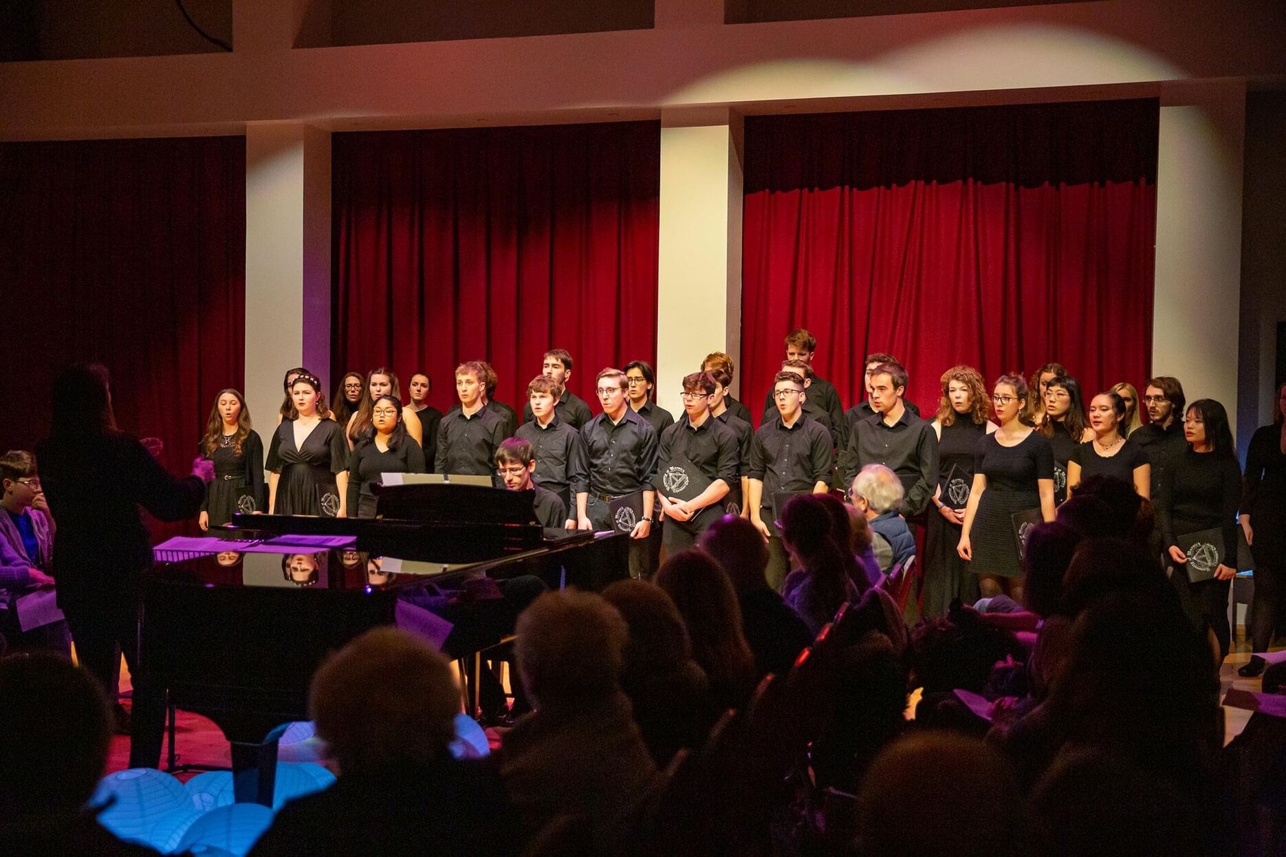 Chamber Choir performing around a grand piano 