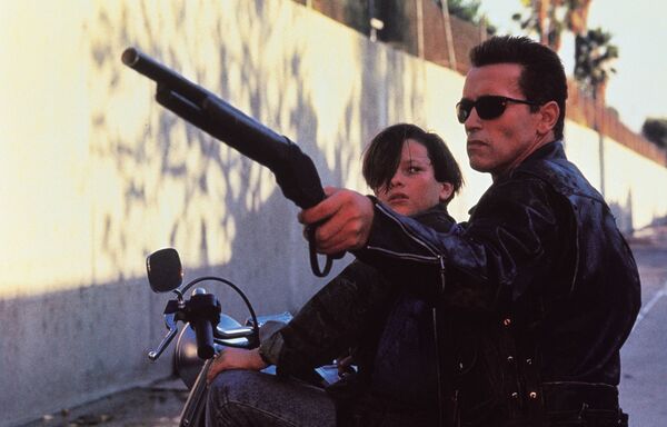 A teenage boy and a human-looking cyborg sit together on a motorcycle. The cyborg aims a rifle. A teenage boy and a human-looking cyborg sit together on a motorcycle. The cyborg aims a rifle.