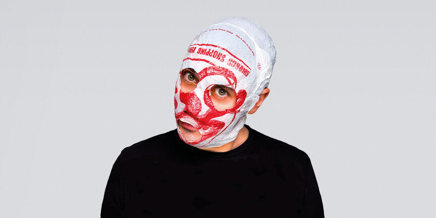 Man with bag on his head looking at camera