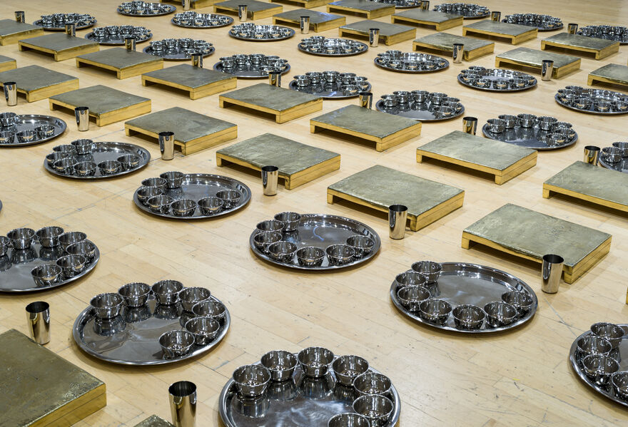 Rows of silver bowls on platters, with cups