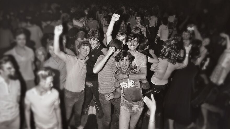 A black and white photo of a group of revellers. 