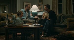 Two couples sit closely together laughing