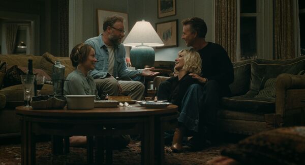Two couples sit closely together laughing