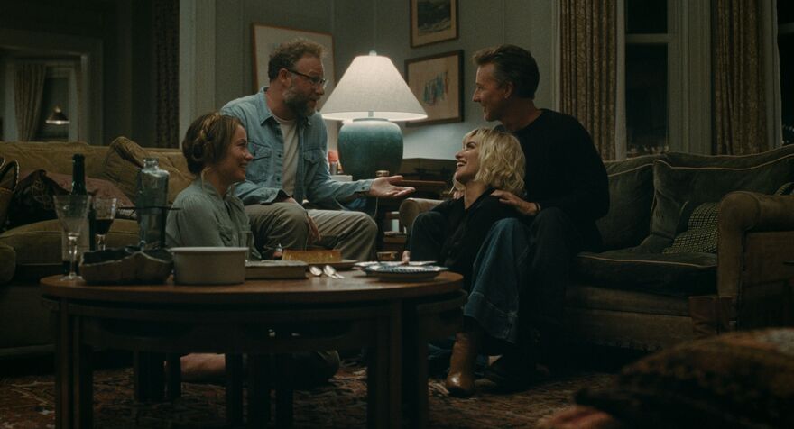 Two couples sit closely together laughing