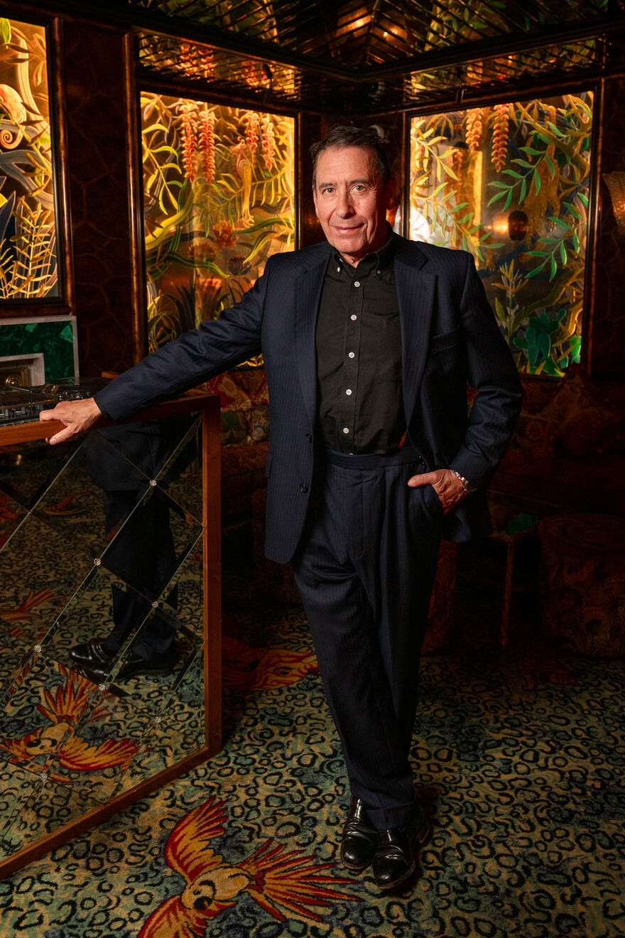 Jools Holland standing against a floral background