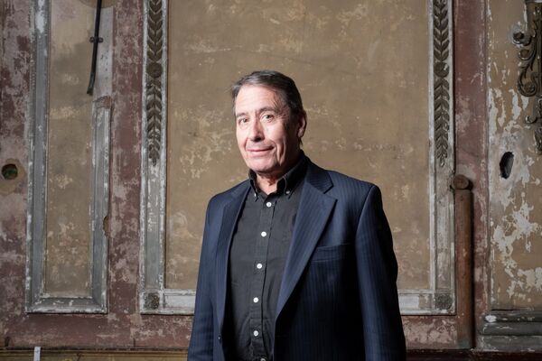 Jools Holland standing in front of a dark wall