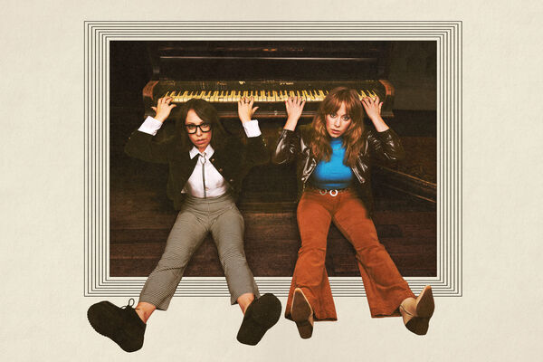 Flo and Joan sat down and leaning against a keyboard