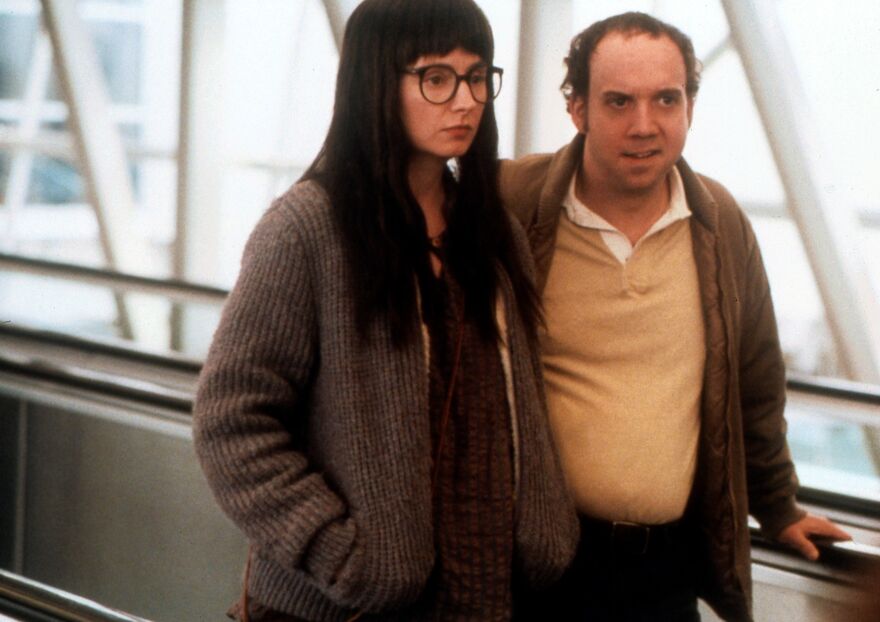 A man and woman on a moving walkway. 