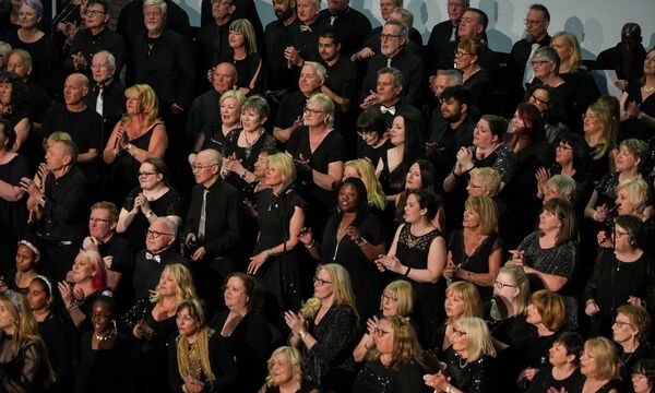 A choir dressed in black singing