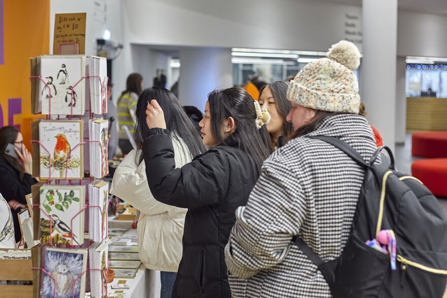 Group of people looking at prints on a stand