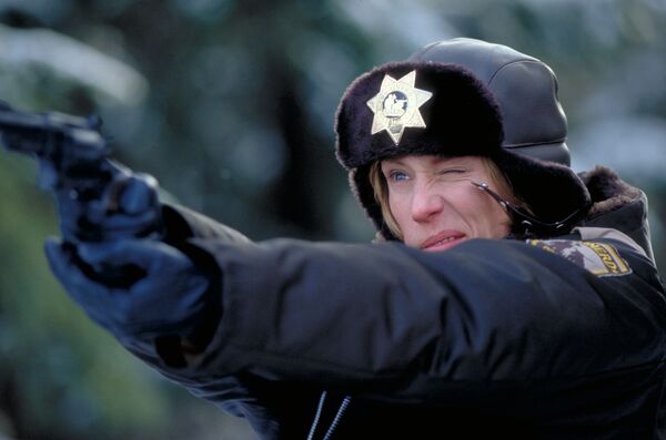 A police officer aims a gun. 