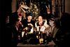 A group of people around a table with candles and a Christmas tree