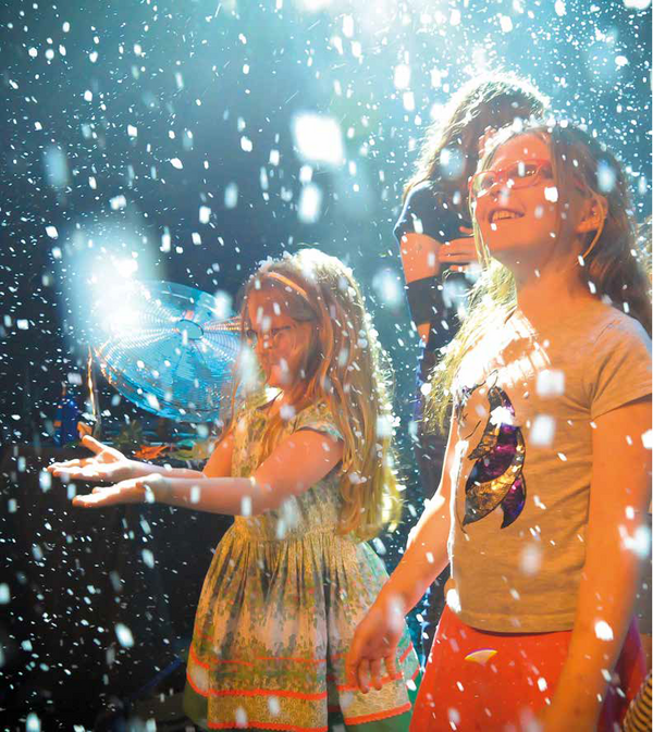Two young people playing in falling stage snow