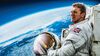 Tim Peake wearing a spacesuit looking out over the earth