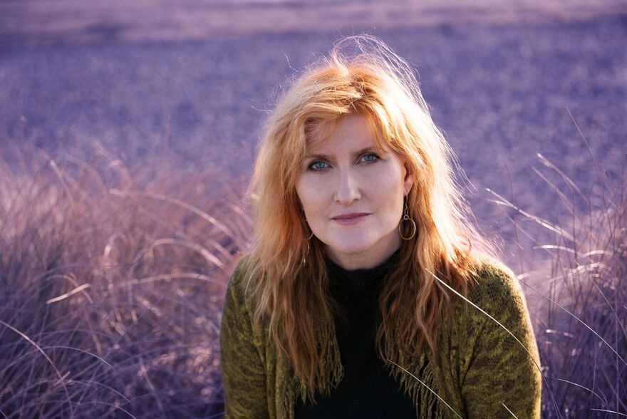 Eddi Reader, a woman with red hair, wearing a green knitted cardigan and looking directly into the camera