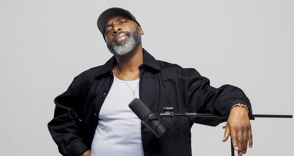 Kane Brown leaning on a microphone