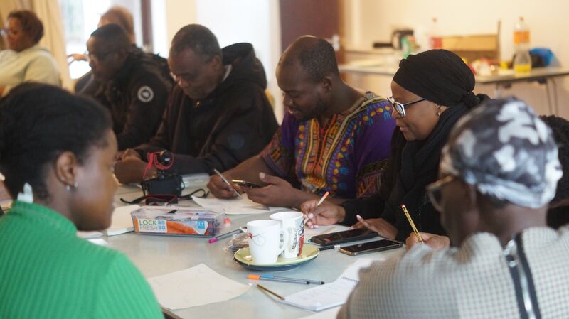 Group of people doing arts and crafts at a table.