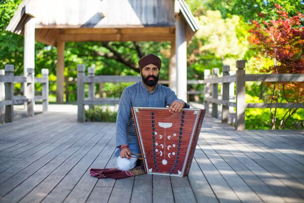 Kaviraj Singh sat on floor with a santoor Kaviraj Singh sat on floor with a santoor
