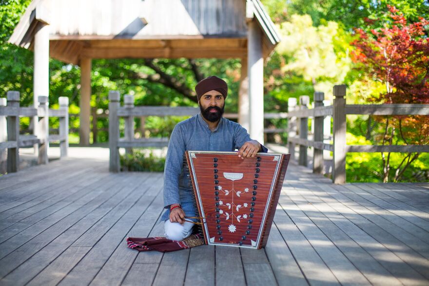 Kaviraj Singh sat on floor with a santoor