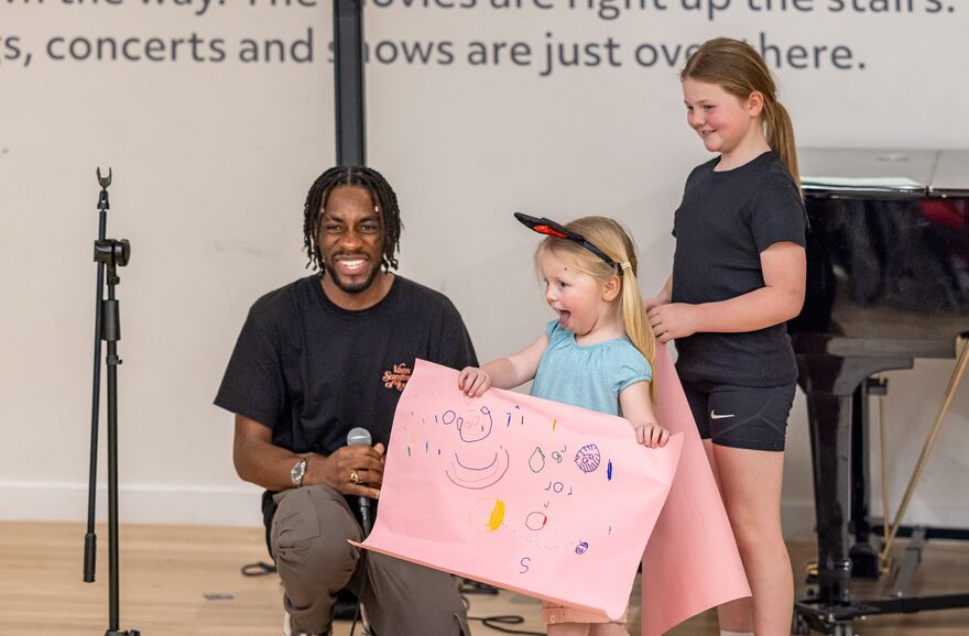Man kneeling next to two young girls