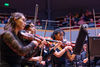 Musicians performing in an orchestra on stage in Butterworth Hall