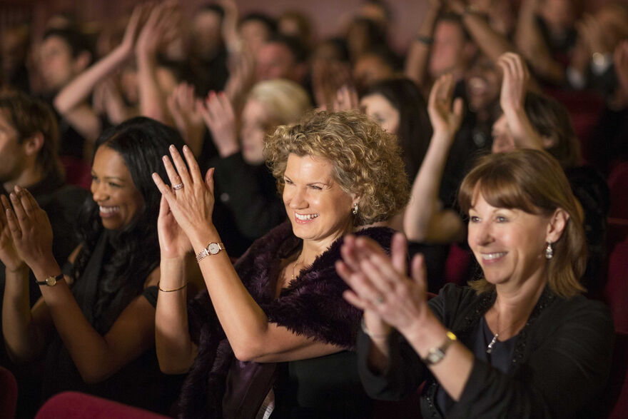 Audience members cheering and clapping