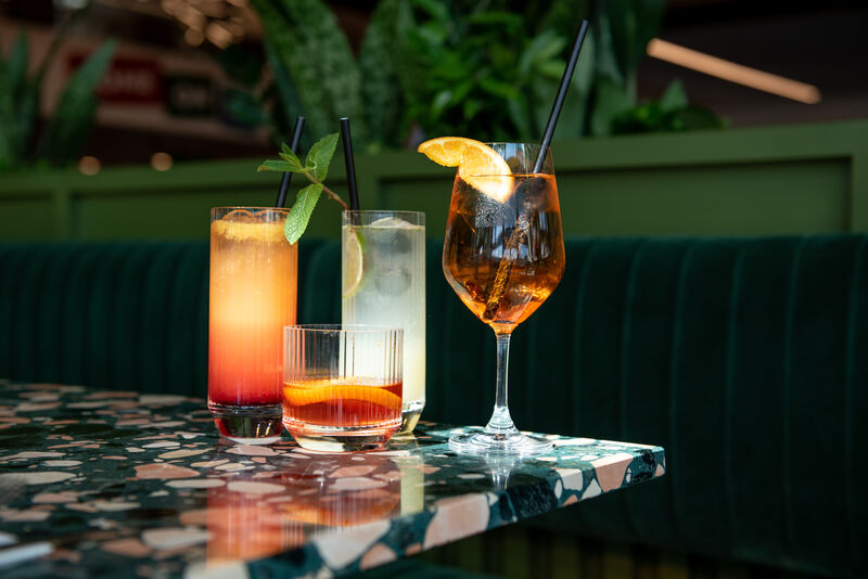 Four different cocktails in a range of different glasses on a table 