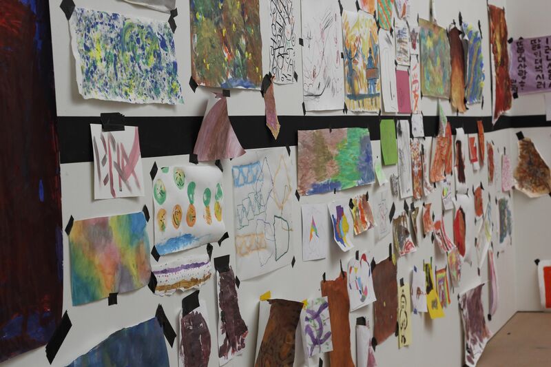 A range of artwork taped to a white wall