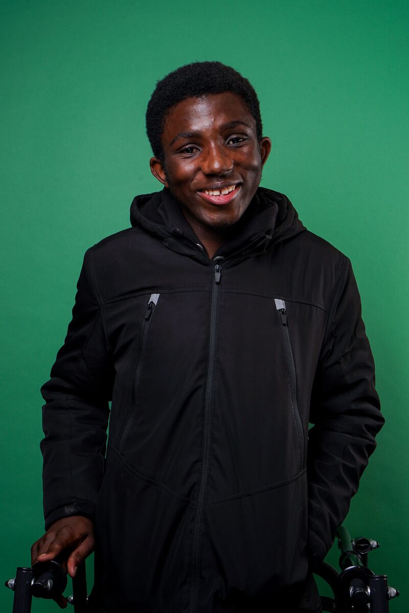 Boy wearing black zipped hoodie in front of a green background