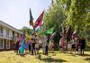 A group of people all holding up large colourful flags at the University of Warwick 