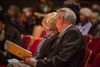 Man and woman looking at programme in their seats
